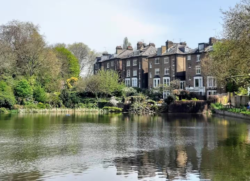 Period houses reflected in a Hampstead Heath pond