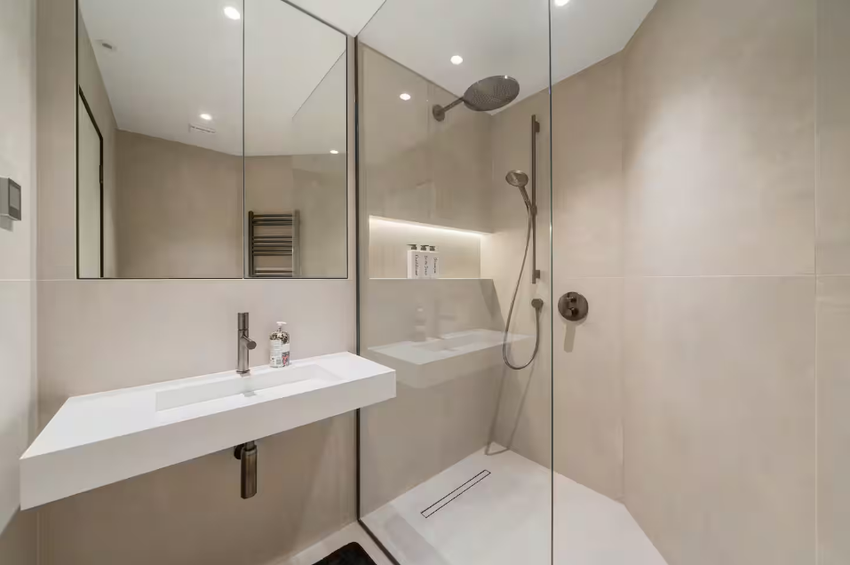 Walk-in rainfall shower with floating stone vanity